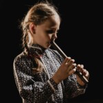 Dziewczynka w tradycyjnym odzieniu grająca na piszczałce wielkopostnej, Zawoja 2025, fot. W. Spyrka Dziewczynka w tradycyjnym odzieniu grająca na piszczałce wielkopostnej, Zawoja 2025, fot. W. Spyrka